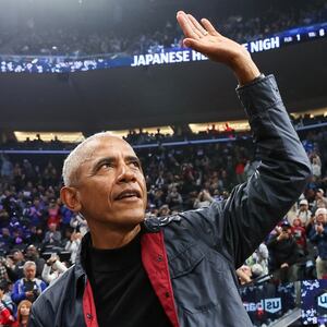 Former President Barack Obama waves to fans during the game between the LA Clippers and the Detroit Pistons