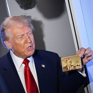 US President Donald Trump holds a mock-up of his $5 million dollar Gold Card visa.