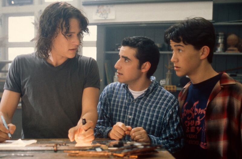 Heath Ledger, David Krumholtz, and Joseph Gordon-Levitt at a school desk in a still from ‘10 Things I Hate About You’