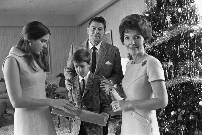 California Governor Ronald Reagan and his wife, Nancy (right), gather around the Christmas tree with children Patti, and Ron, Jr., December 1970.