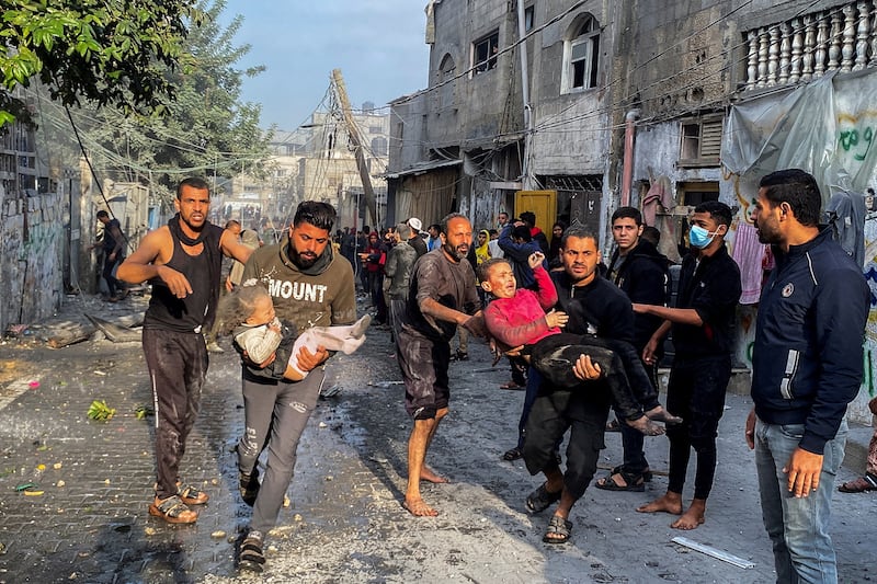 Palestinians carry wounded children following an Israeli strike on a house in Rafah.