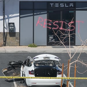 LAS VEGAS, NEVADA - MARCH 18: Investigators look over the scene at a Tesla Collision Center after an individual used incendiary devices to set several vehicles on fire on March 18, 2025 in Las Vegas, Nevada.