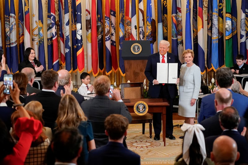 President Donald Trump stands with U.S. Secretary of Education Linda McMahon as he shows off an executive order to shut down the Department of Education at the White House in Washington, D.C. on March 20, 2025.