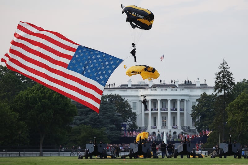 A member of the U.S. Army Golden Knights Parachute Team displays an American flag while landing on the Ellipse near the White House on July 4, 2020 in Washington.