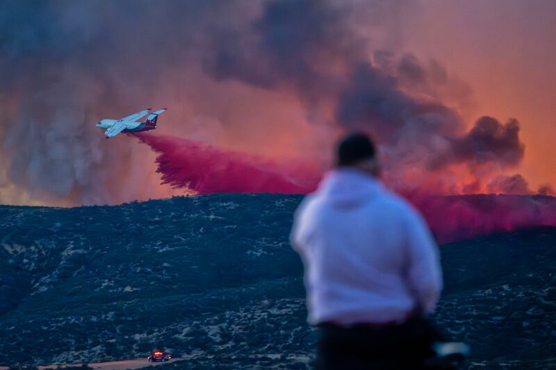 A firefighting aircraft makes a drop on the Hughes fire in Castaic