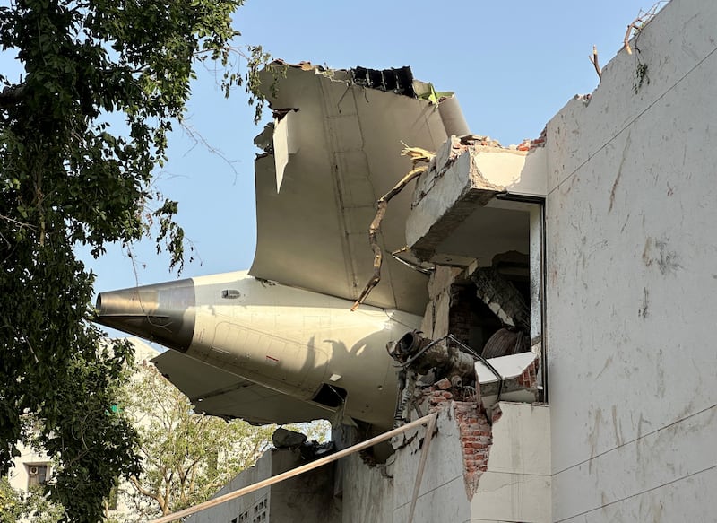 The tail of the aircraft was stuck on a building—students at a medical college hit by the plane were among those killed.