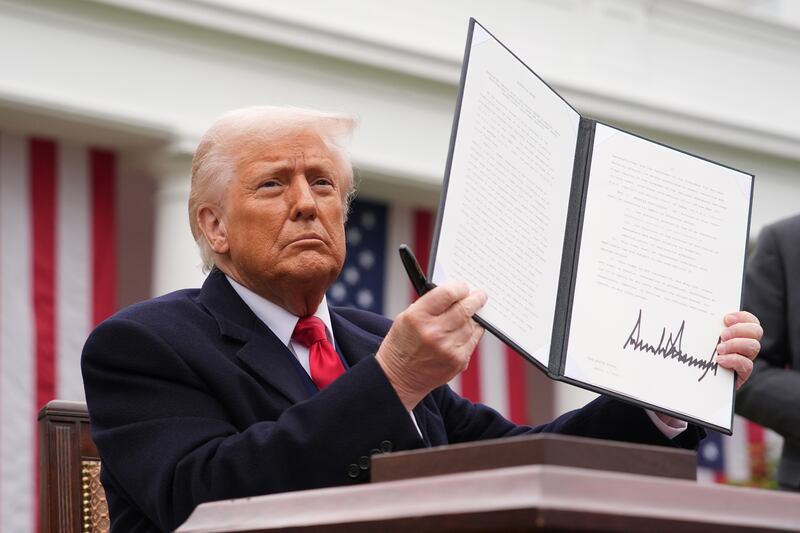 President Donald Trump displays a signed executive order imposing tariffs on imported goods during a “Make America Wealthy Again” trade announcement.