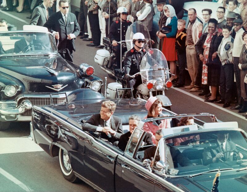 US President John F Kennedy, First Lady Jacqueline Kennedy, Texas Governor John Connally, and others smile at the crowds lining their motorcade route in Dallas, Texas, on November 22, 1963.