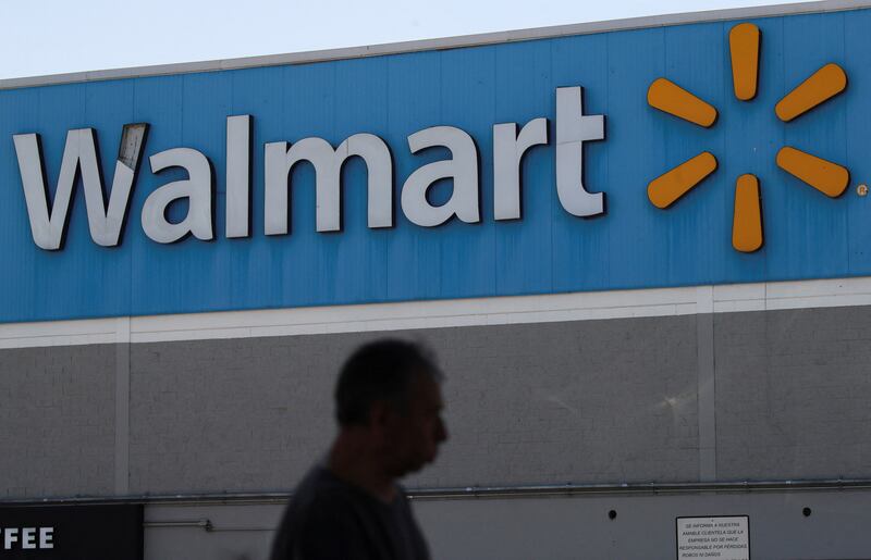 A man walks past the logo of Walmart on the facade at a store in Mexico City, Mexico
