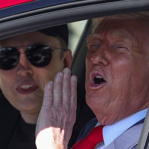Elon Musk and Donald Trump sit inside a Tesla.