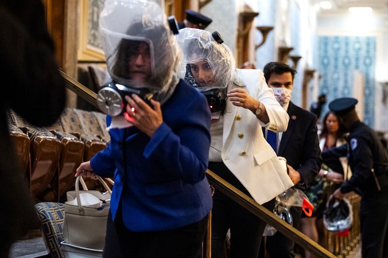 UNITED STATES - JANUARY 6 (FILE): Reps. Sara Jacobs, D-Calif., center, and Annie Kuster, D-N.H., left, take cover as rioters attempt to disrupt the joint session of Congress to certify the Electoral College vote on Wednesday, January 6, 2021. (Photo By Tom Williams/CQ-Roll Call, Inc via Getty Images)