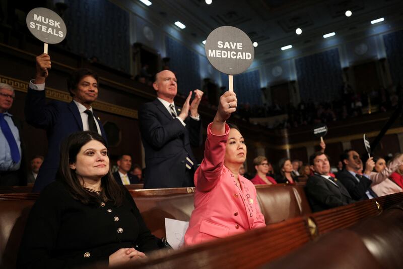 Rep. Jill Tokuda (D-HI) holds a protest sign with fellow Democrats as U.S. President Donald Trump addresses a joint session of Congress at the U.S. Capitol on March 04, 2025 in Washington, DC.