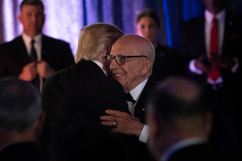 US President Donald Trump (L) is embraced by Rupert Murdoch, Executive Chairman of News Corp, during a dinner to commemorate the 75th anniversary of the Battle of the Coral Sea during WWII onboard the Intrepid Sea, Air and Space Museum May 4, 2017 in New York, New York. / AFP PHOTO / Brendan Smialowski        (Photo credit should read BRENDAN SMIALOWSKI/AFP via Getty Images)
