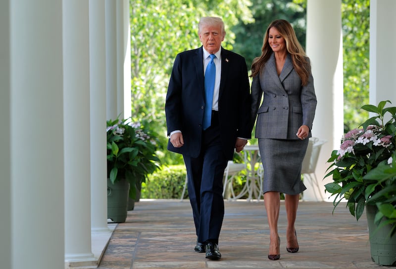 President Donald Trump and first lady Melania Trump arrive at the signing ceremony for the TAKE IT DOWN Act in the Rose Garden of the White House on May 19, 2025.