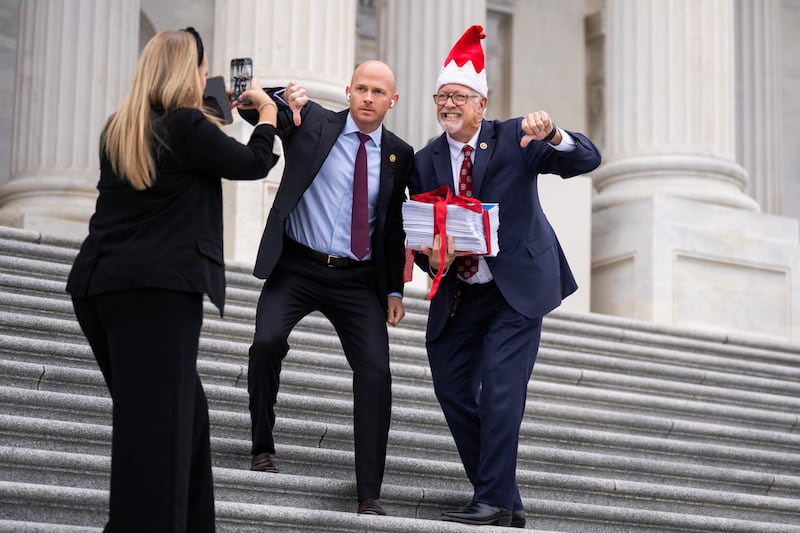 Reps. Randy Weber, R-Texas, right, and William Timmons, R-S.C., pose with a copy of the continuing resolution bill on the House steps of the U.S. Capitol.