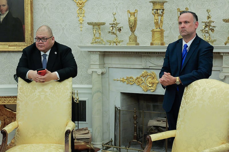 WASHINGTON, DC - APRIL 23: White House Communications Director Steven Cheung (L) and Deputy Chief of Staff Dan Scavino listen to U.S. President Donald Trump talk to reporters after signing executive orders in the Oval Office at the White House on April 23, 2025 in Washington, DC. Trump signed seven executive orders related to education policy. (Photo by Chip Somodevilla/Getty Images)