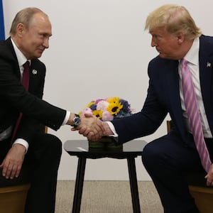 U.S. President Donald Trump (R) greets Russian President Vladimir Putin (L).