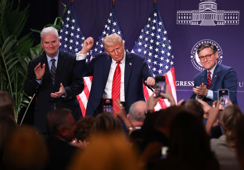 President Donald Trump dances as House Majority Whip Tom Emmer, left, and House Speaker Mike Johnson, right, look on at the Republican Issues Conference.