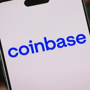 CHONGQING, CHINA - FEBRUARY 10: In this photo illustration, the Coinbase logo is displayed on a smartphone screen in front of a stock chart showcasing Coinbase's financial performance, cryptocurrency market trends, blockchain technology developments, and global business activity on February 10, 2025, in Chongqing, China. (Photo illustration by Cheng Xin/Getty Images)