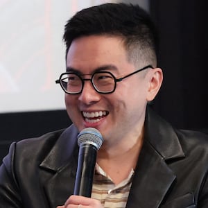Bowen Yang holding a mic