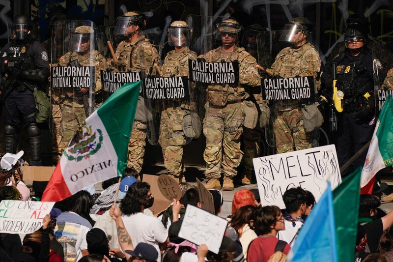 California National Guard troops and police officers stand guard as people attend a rally against federal immigration sweeps, in Los Angeles, California, U.S. June 9, 2025.