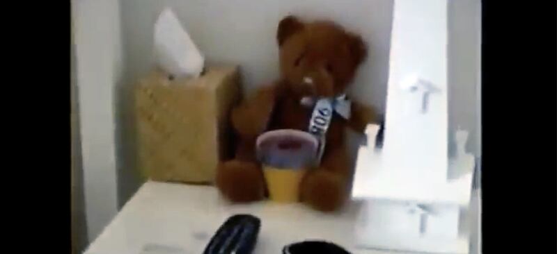 A plushie teddy bear, box of tissues, remote controls and an ornamental obelish sit atop a bedside table in a guest bedroom in Jeffrey Epstein's Palm Beach mansion.