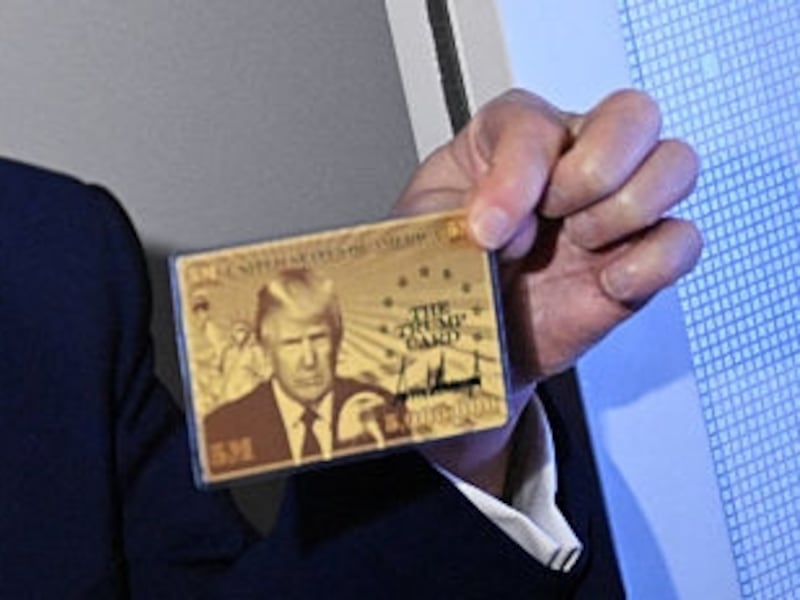 US President Donald Trump holds the $5 million dollar Gold Card as he speaks to reporters while in flight on board Air Force One, en route to Miami, Florida on April 3, 2025.