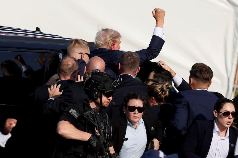 Donald Trump gestures as he gets into a vehicle 