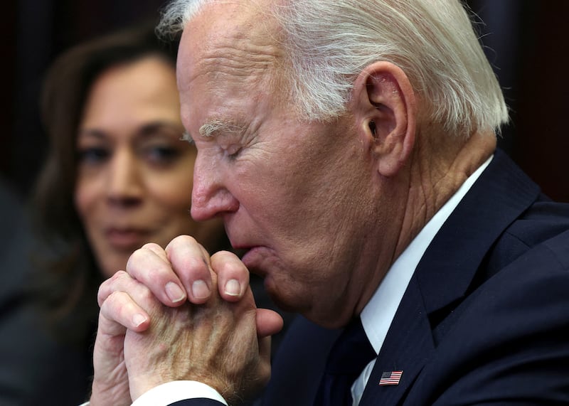 Joe Biden, flanked by Kamala Harris, closes his eyes as he listens to a briefing on the federal response to the wildfires.