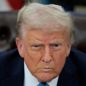 Donald Trump talks to reporters after signing an executive order.