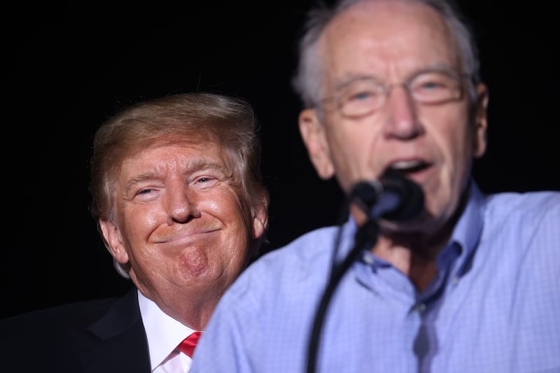 Donald Trump smiles as Chuck Grassley (R-IA)  speaks during a rally at the Iowa State Fairgrounds on October 09, 2021 in Des Moines, Iowa.